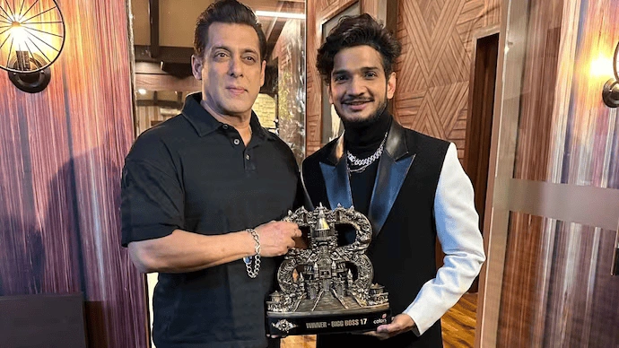 Munawar Faruqui holding  Bigg Boss 17 Title with Salman Khan